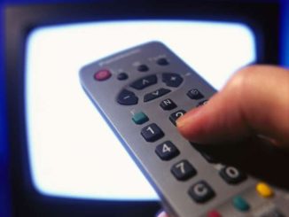 person pointing a remote at a television