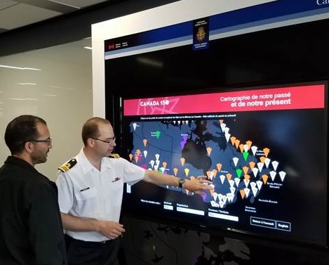 Two people using the interactive defense map captured by GTA weekly Toronto News