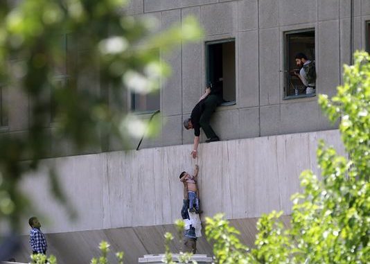 Policeman helping a child out of a building window during terrorist attack
