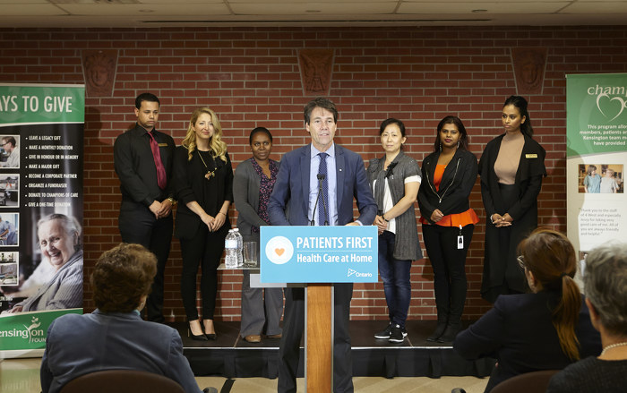 Minister Hoskins speaking at a podium with Kensington Health staff