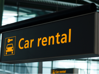 Car rental signage at a European airport as services adapt to EU border checks travel delays for non-EU travellers.